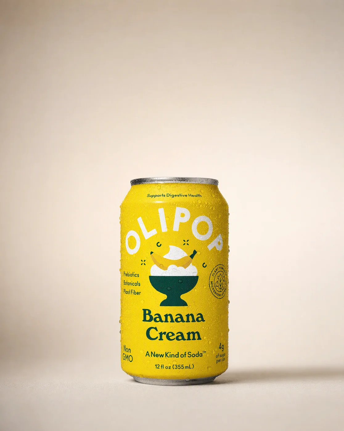 OLIPOP Banana Cream can standing off centre on a warm bone grey paper sweep, empty top third