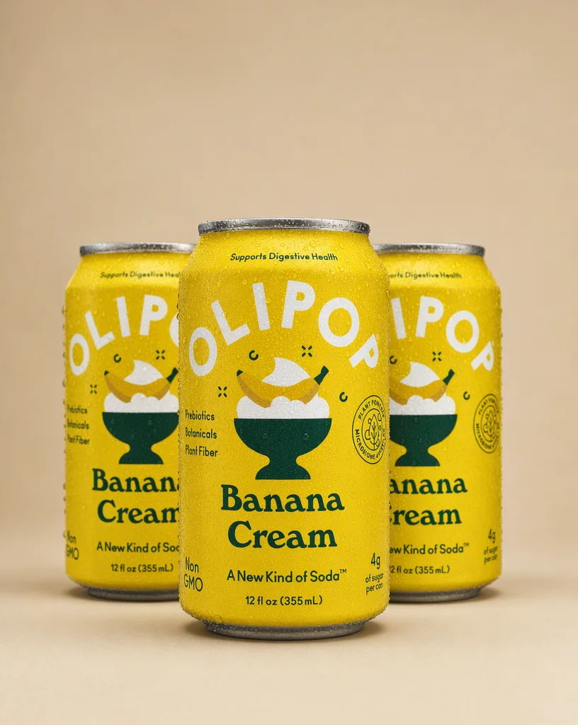 Three OLIPOP Banana Cream cans clustered on a putty backdrop, the front one sharp